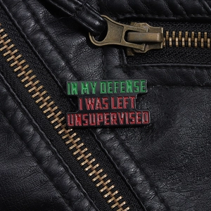 Macro shot of a funny enamel pin on black leather with a humorous quote text