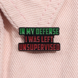 Macro detail of enamel pin with funny quote on pink denim fabric background