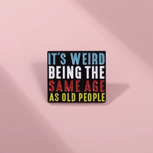 Macro detail of rectangle enamel pin with humorous text on a soft pink background