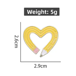 Detail of yellow heart pencil enamel pin with Make More Art slogan and dimensions