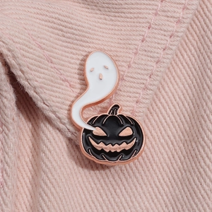 Détail de la broche émaillée fantôme et citrouille avec bordures en métal or rose poli