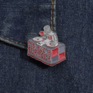 Detail of creative knight DJ booth enamel brooch with 'TIS BUT A SCRATCH' text on denim