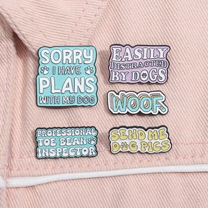 Macro detail of colorful dog themed enamel pins on pink denim fabric background