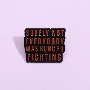 Black enamel pin with orange text Surely Not Everybody Was Kung Fu Fighting