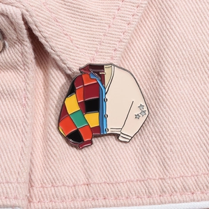 Detailed close-up of a vintage enamel cardigan pin with colorful patchwork and stars