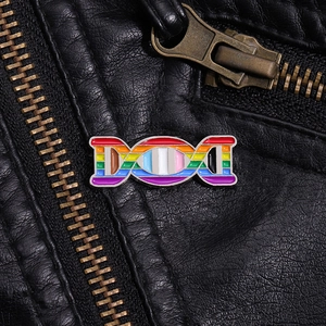 Detailed close-up of rainbow DNA helix enamel pin displayed on a black leather jacket