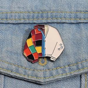 Detailed enamel brooch pin styled as a patchwork cardigan on blue denim jacket