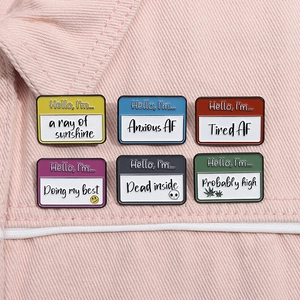 Close-up of 6 colorful enamel lapel pins with humorous phrases on pink denim background
