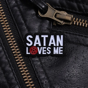 Macro shot of Satan Loves Me enamel pin with pentagram on black leather jacket detail