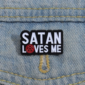 Gothic 'SATAN LOVES ME' enamel pin with red pentagram on blue denim fabric