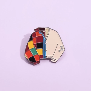 Enamel cardigan pin with colorful patchwork design and silver stars on sleeves
