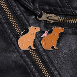 Vue macro de badges capybara en émail sur un blouson en cuir noir avec des détails métalliques