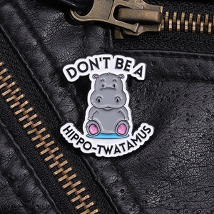 Macro shot of a cartoon hippo enamel pin on a black leather jacket with metal zipper