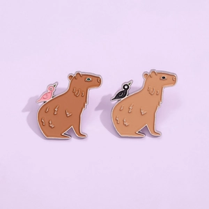 Ensemble de broches émaillées capybara avec oiseaux et motifs d'éclairs sur fond lilas