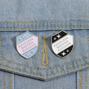 Detail of creative shield enamel pins on denim jacket showing the Pointless Meeting slogan