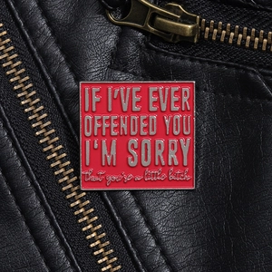 Detail of red enamel badge with sarcastic quote on black leather jacket lapel