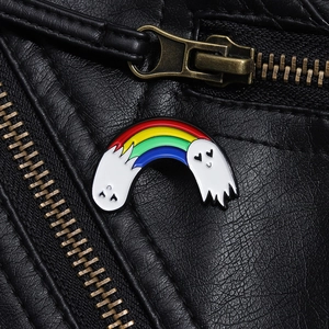 Detail of creative rainbow ghost enamel brooch pinned on a black leather jacket texture