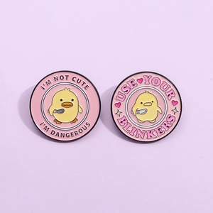 Cute yellow duck enamel pins with humorous text on pink metal badges for clothes