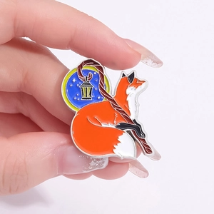 Detail of red fox brooch with magic lantern being held to show small product scale