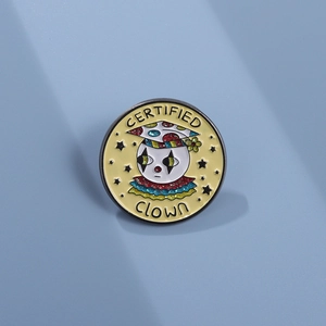 Detail of a round enamel clown badge featuring the text Certified Clown on blue background