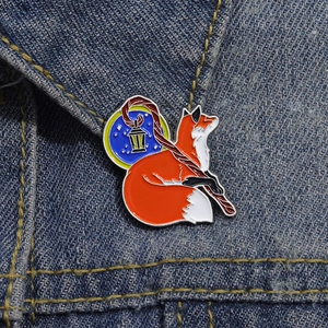 Creative enamel cartoon red fox brooch with magic wand pinned on blue denim jacket