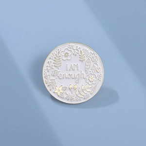 Minimalist round enamel brooch with golden floral patterns and I AM enough inscription