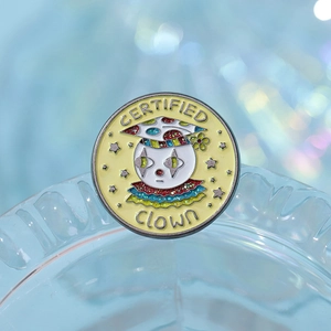 Detailed macro shot of a round certified clown enamel pin with colorful academic cap