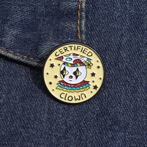 Detail of colorful enamel clown pin with Certified Clown text on denim fabric