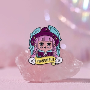 Close-up of a cute anime witch enamel pin featuring pink hair and a POWERFUL banner detail