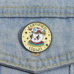 Detail of a Certified Clown enamel pin with glitter finish on a denim jacket pocket