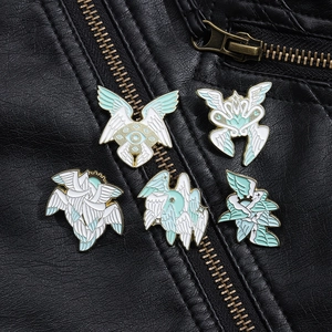 Detailed macro of seraphim enamel pins with wings and eyes on black leather jacket