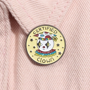 Detailed view of round enamel clown pin with Certified Clown text on pink fabric