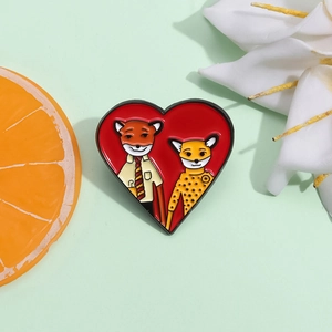 Cartoon animal enamel heart brooch with fox and leopard illustrations on a green background