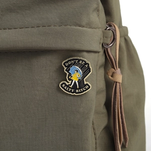 Detail of creative girl in yellow raincoat enamel pin with Don't Be A Salty Bitch text