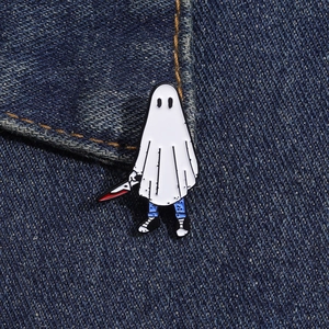 Détail de la broche fantôme en émail avec un couteau sur tissu denim d'Halloween