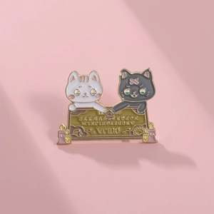 Macro di una spilla in smalto a forma di gatto Ouija su uno sfondo rosa minimalista