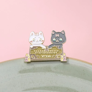 Dettaglio della spilla smaltata con gatto bianco e nero stile Ouija su ceramica