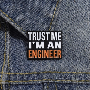 Detail of Trust Me I'm An Engineer enamel pin on a blue denim jacket collar