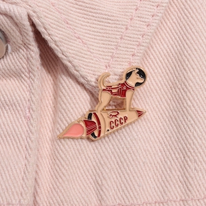 Detailed macro of CCCP space dog enamel pin on pink denim jacket showing craftsmanship