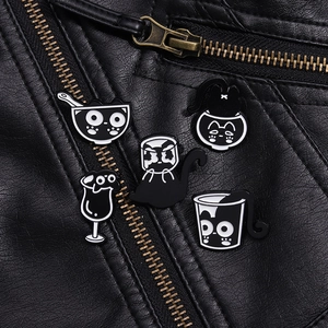 Gros plan de pins en émail de chat dessin animé noir et blanc sur veste en cuir