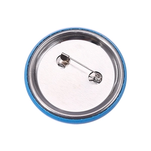 Macro view of round tinplate badge back with silver metal plate and safety pin buckle