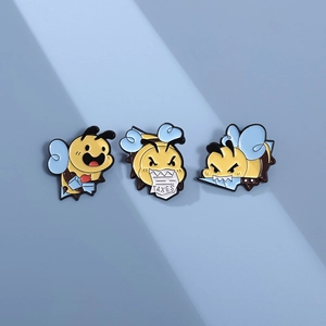 Close-up of funny bee enamel pins featuring a dagger and a taxes paper design
