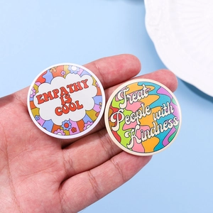 Detail of round tinplate badges with Empathy is Cool and Treat People with Kindness text