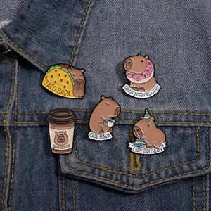 Cinq épingles en émail de capybara mignonnes sur une veste en jean avec jeux de mots