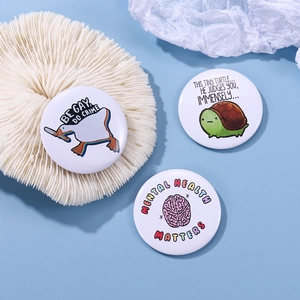 Three round tinplate badges featuring funny animals and mental health slogans on blue background