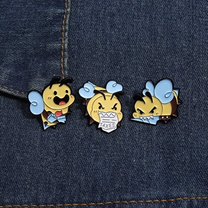Detailed view of cartoon bee enamel pins on denim, featuring tax and knife designs