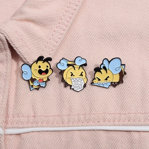 Three cartoon bee enamel brooches including tax paper design on pink denim jacket