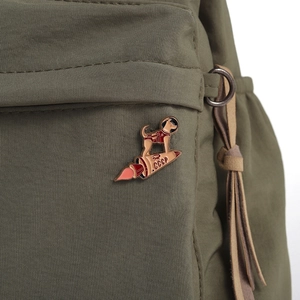 Close-up of enamel brooch featuring Soviet space dog Laika on CCCP rocket and backpack