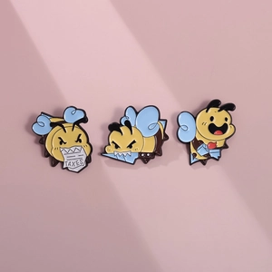Detailed macro view of three quirky enamel bee pins with yellow and blue lacquer finish