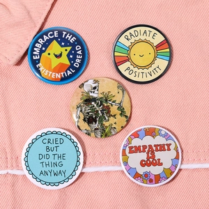 Set of five colorful tinplate badges with creative slogans and animal designs on pink fabric